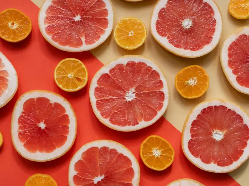 Pomelos y mandarinas cortados por la mitad, listos para disfrutar de los beneficios del pomelo en ayunas.