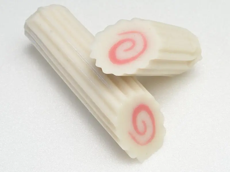 Dwa kawałki narutomaki, japońskiej rybnej pasty z różową spiralą w środku.