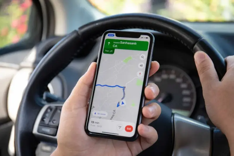 Dłoń trzyma telefon z nawigacją pokazującą trasę do Sarıhasanlı Cd. Czas dojazdu 19 minut. Ile punktów za telefon?