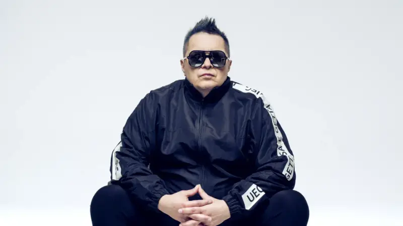 Marek "Mrozu" Mróz w okularach i czarnej kurtce z napisem "GETTA", jakby szykował się na koncert zespołu Munka Staszczyka.