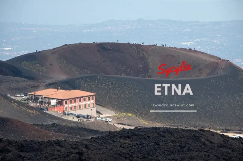 Wulkan Etna na Sycylii, z charakterystycznym budynkiem i turystami na zboczu. Odkryj niezwykłe walory przyrodnicze Włoch.