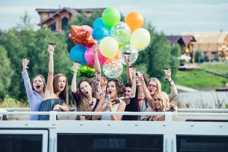 Radosne kobiety z kieliszkami i balonami świętują wieczór panieński. Mnóstwo kolorowych niespodzianek na wieczór panieński!