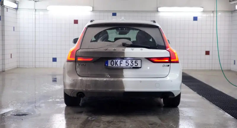Volvo V90, halvtvättad. En sida är täckt av lera, den andra skiner efter avfettning bil.