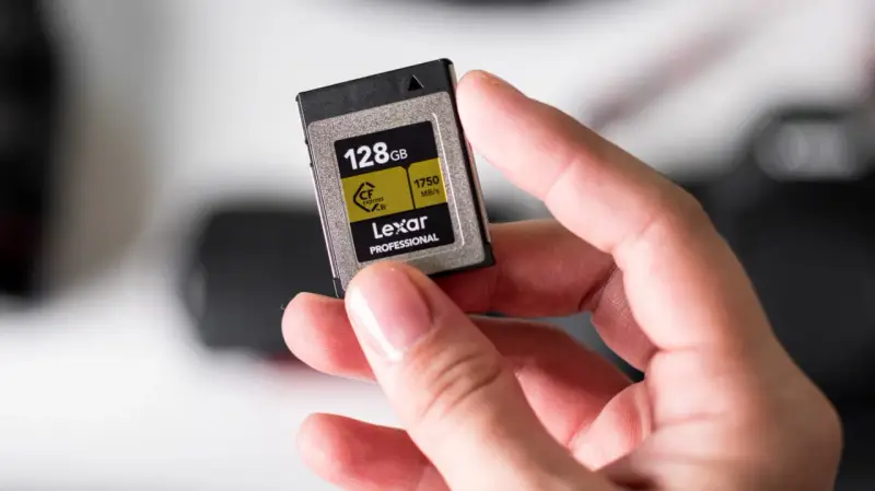 Dłoń trzyma kartę pamięci Lexar Professional 128GB CFexpress B, jedną z najszybszych klas kart pamięci.
