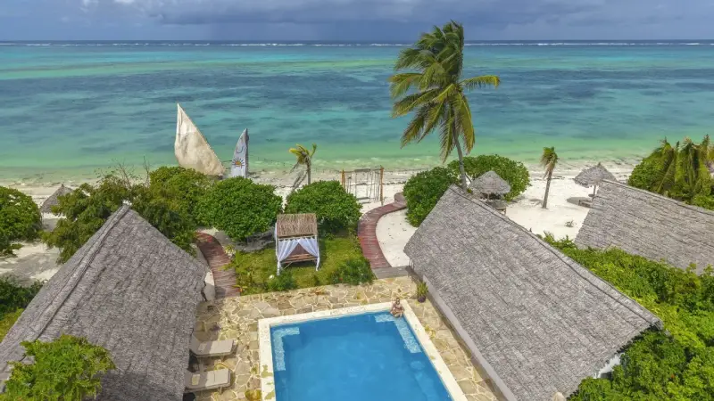 Zanzibar w lutym: słoneczna pogoda, turkusowe morze, palmy i urocze domki z krytymi dachami. Idealne miejsce na relaks.