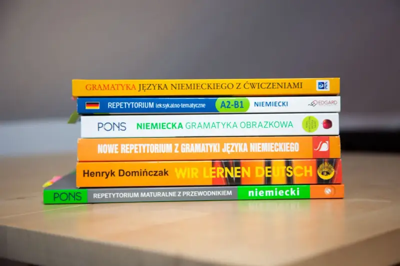 Stos książek do nauki niemieckiego: "Gramatyka języka niemieckiego", "Repetytorium", "Wir lernen Deutsch". Gotowe lekcje niemieckiego czekają!