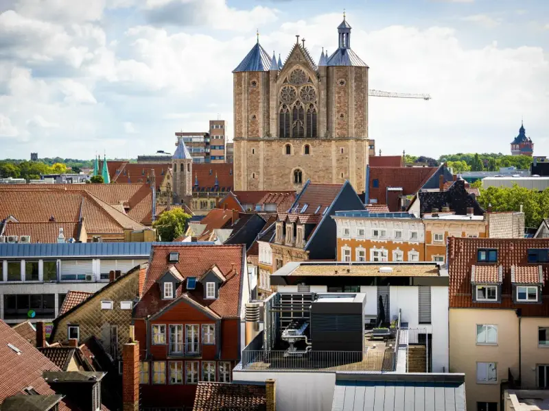 Blick über Dächer auf eine Kirche. Über den Austritt aus der Kirche und steuerliche Folgen wird nachgedacht.