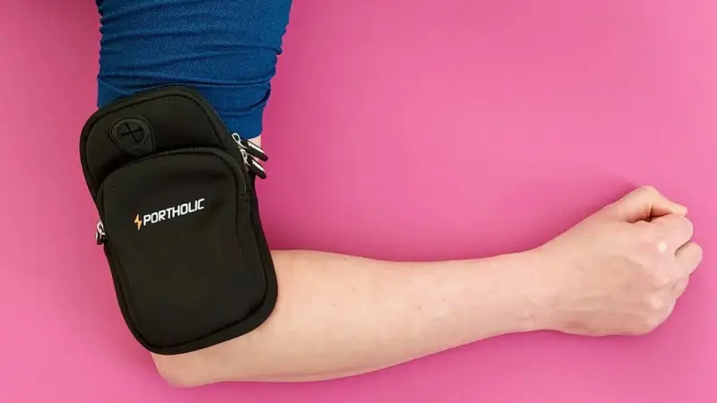 Kleiner schwarzer Portholic-Beutel am Arm, praktisch für Sport oder unterwegs.