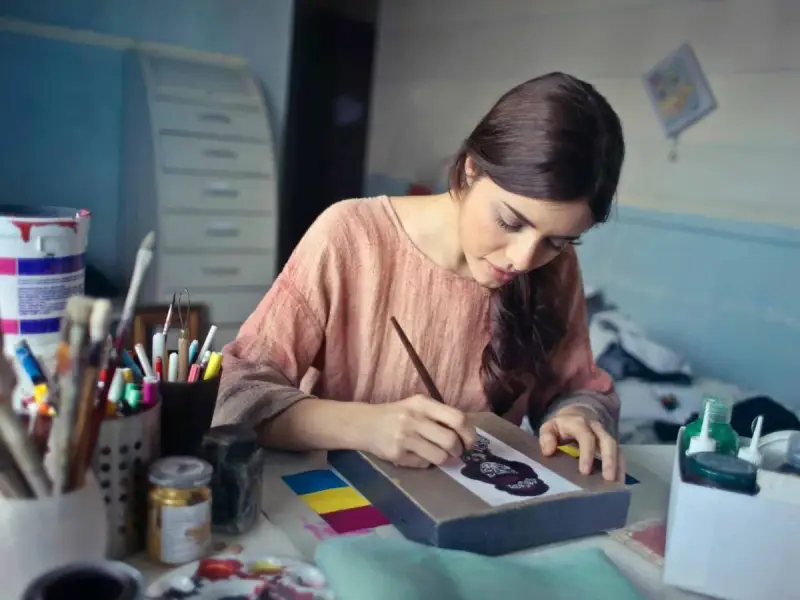 Une jeune artiste peintre auto entrepreneur crée une œuvre d'art dans son atelier.