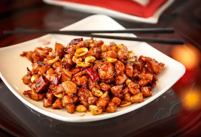 Kurczak Kung Pao, jak Król Małp, w sosie z orzeszkami ziemnymi i papryczkami chili.