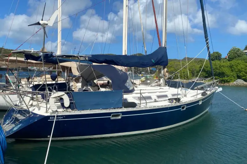 Voilier bleu "Iguana" au mouillage, sous un ciel bleu et nuageux. La magie du soleil sur l'eau, 44 avis.