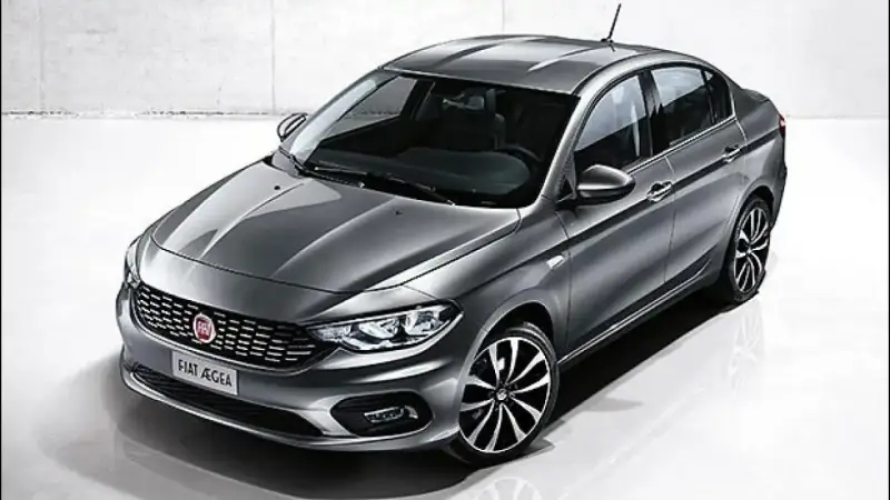 La Fiat Egea grigia, un'elegante berlina, si presenta in uno studio con un design moderno e cerchi sportivi.
