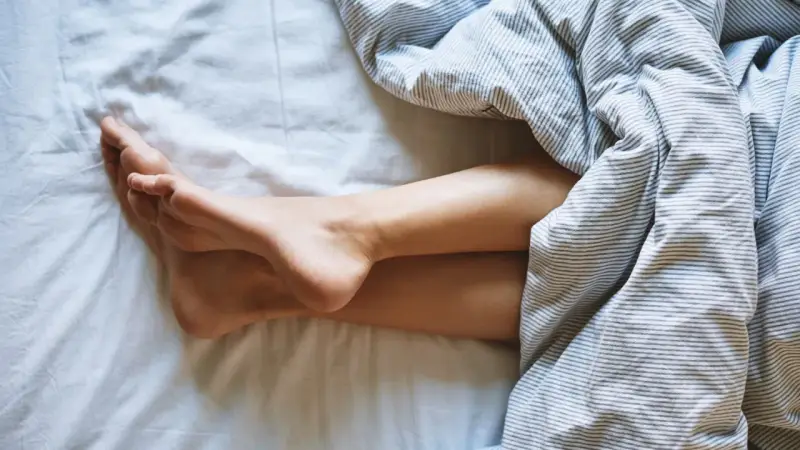 Nogi pod pościelą. Zastanawiasz się, jak często zmieniać piżamę? Czysta pościel to podstawa.