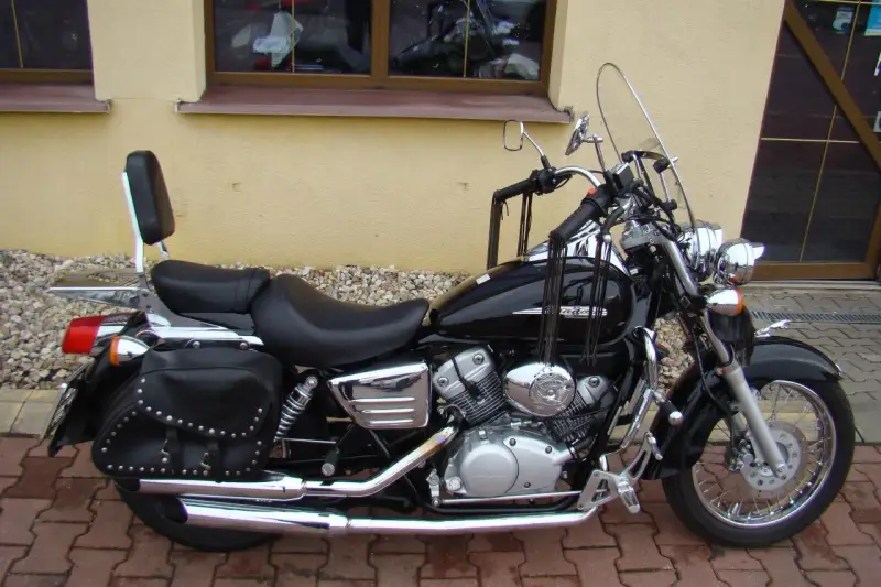 Czarny motocykl Honda Shadow 125, z sakwami i oparciem. Idealny na podróże, poznaj jego honda shadow 125 dane techniczne.