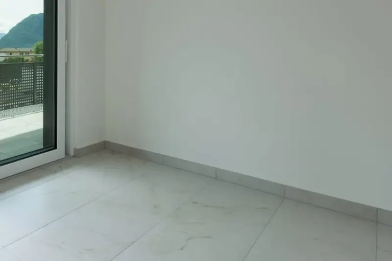 Plinthe grise discrète pour carrelage imitation marbre. Un choix idéal pour une finition propre et moderne.