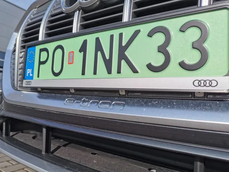 Zielone tablice rejestracyjne z numerem PO 1NK33 na samochodzie Audi e-tron.