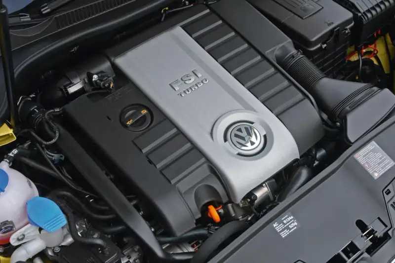 Silnik Volkswagen z napisem FSI TURBO. Widoczny jest symbol marki i elementy układu dolotowego.