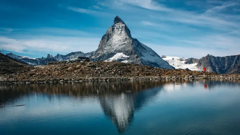 Majestatyczny Matterhorn odbija się w spokojnym jeziorze. Czy Szwajcaria jest w Schengen? Tak, podróżni mogą swobodnie przekraczać granice.
