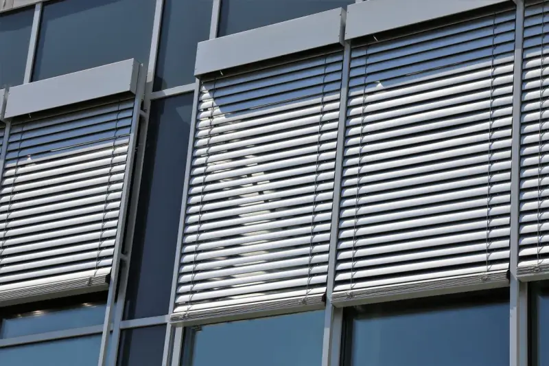 Volets roulants modernes sur une façade de bâtiment. L'image suggère la durabilité et la longévité du moteur de volet roulant.