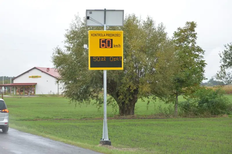 Tablica informuje o kontroli prędkości: 60 km/h, mandat 50 zł. To przypomnienie o taryfikatorze mandatów.