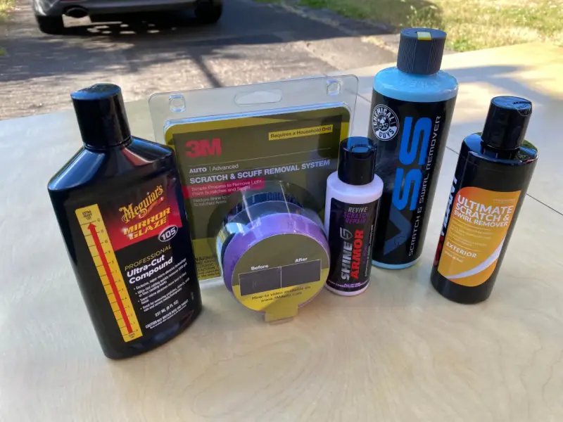 Car scratch removal products, including rubbing compound, are laid out, ready to tackle paint scratches and swirls.