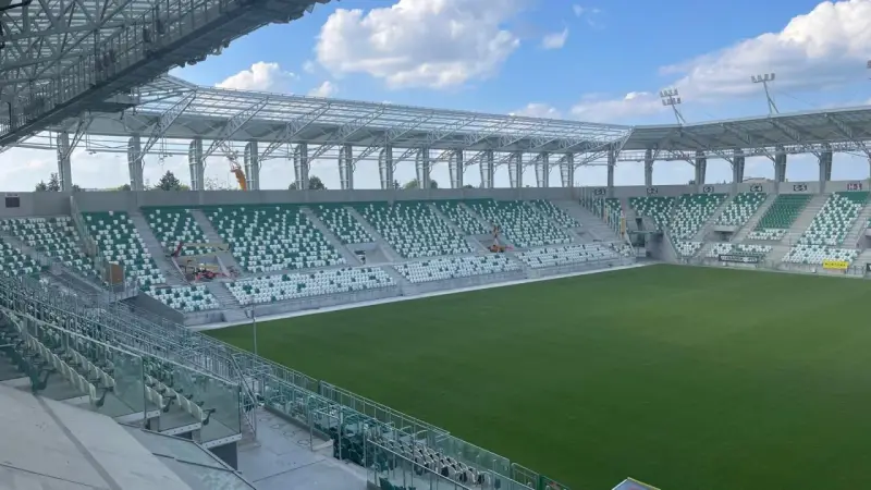 Puste sektory stadionu Radomiaka czekają na kibiców. Zielona murawa i nowoczesna konstrukcja dachu tworzą imponujący widok.