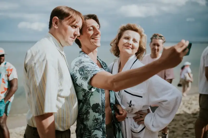 Trzech bohaterów z filmu "Teściowie 2" robi selfie na plaży. Gdzie obejrzeć ten hit?