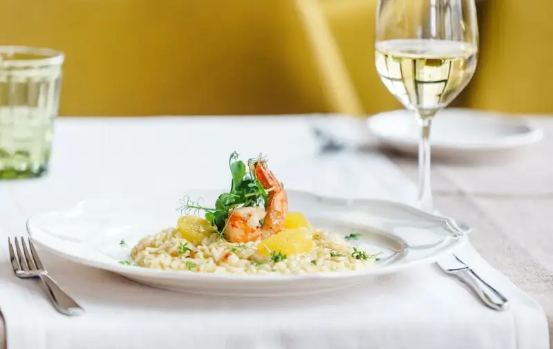 En krämig risotto med räkor och apelsin, perfekt ackompanjerad av ett glas vitt vin till risotto.