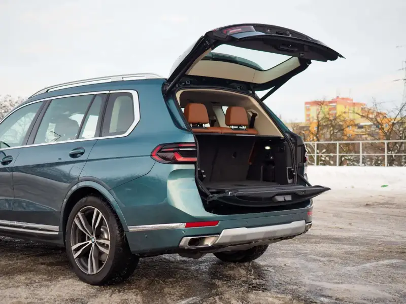 Zielony BMW X7 z otwartym bagażnikiem, idealny na rodzinne wyjazdy. Sprawdź aktualną bmw x7 cena.