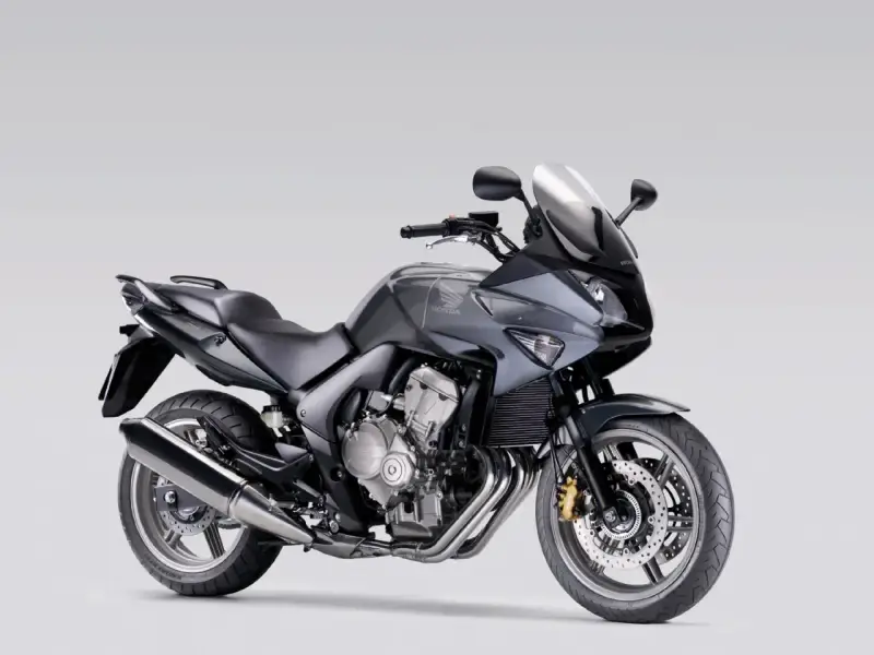 Szary motocykl Honda CBF 600, zgrabny i sportowy, idealny dla osób szukających komfortu i odpowiedniej wysokości siedzenia.