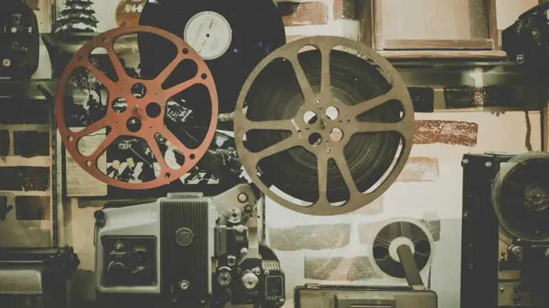 Stare klisze filmowe i projektor, gotowe do odtworzenia historii pełnej emocji i dramatów.