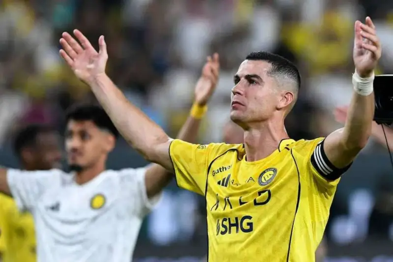 Cristiano Ronaldo w żółtej koszulce z podniesionymi rękami. Ile goli strzelił Ronaldo?
