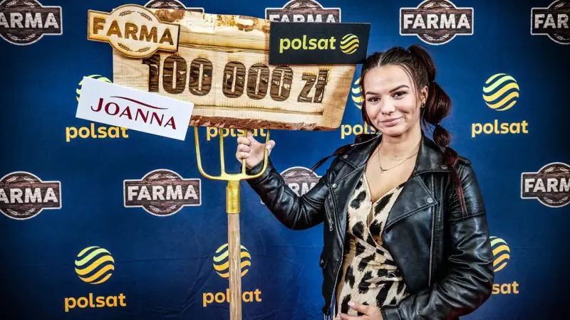 Joanna z "Farmy" trzyma widły i tablicę z napisem "100 000 zł".
