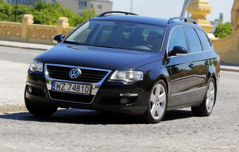 Czarny Volkswagen Passat B6 2.0 TDI 140KM na polskich tablicach rejestracyjnych WZ 74810, jadący po brukowanej drodze.