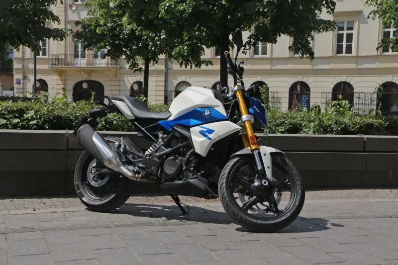 Biało-niebieski motocykl BMW G 310 R na tle kamienicy. Sprawdź jego dane techniczne!
