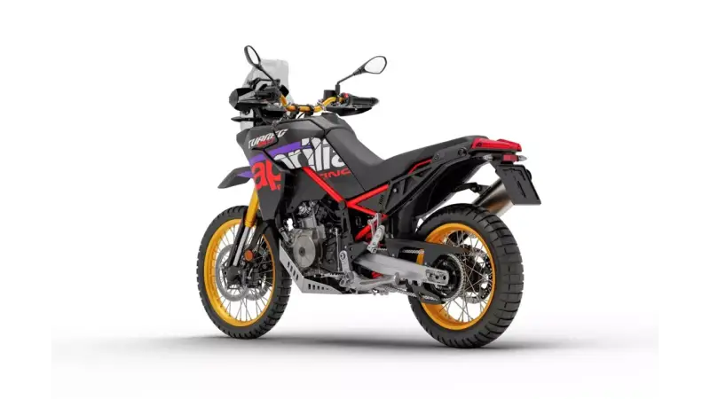 Czarny motocykl Aprilia Tuareg 660 z czerwonymi i fioletowymi akcentami, złote felgi. Dane techniczne tego modelu są imponujące.