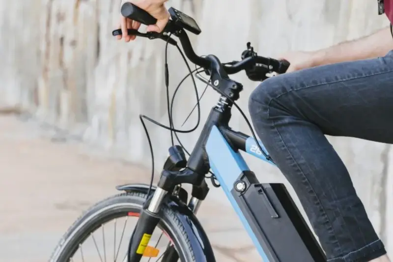 Osoba na rowerze elektrycznym, który jest pojazdem mechanicznym, jedzie po mieście.
