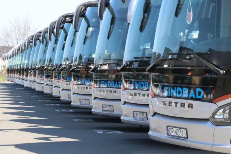 Rząd białych autokarów Sindbad Setra gotowych do podróży z Niemiec do Polski.