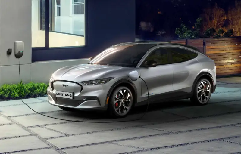 Srebrny Mustang Mach-E, nowoczesny bev, ładuje się przy domu. Czysta energia na noc.