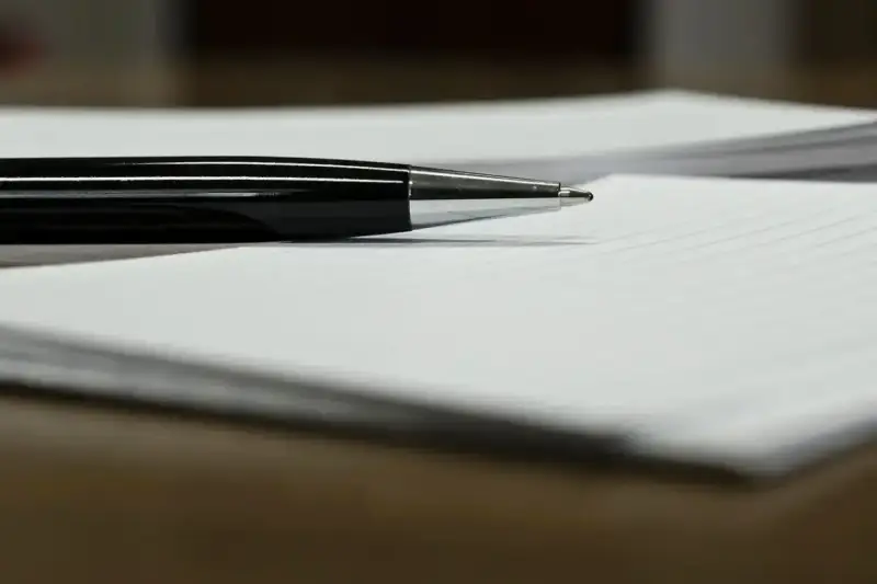 Czarny długopis leży na papierze, gotowy do podpisania ważnego dokumentu, np. pełnomocnictwa.