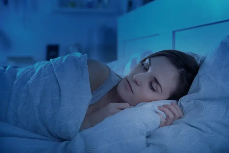 Kobieta w głębokim, spokojnym śnie. Jej twarz jest zrelaksowana, a ciało otulone kołdrą. To idealny senaxa.