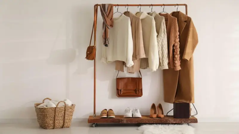 Un armario cápsula mujer con prendas de punto, abrigos y bolsos en tonos tierra. Perfecto para un estilo minimalista y chic.