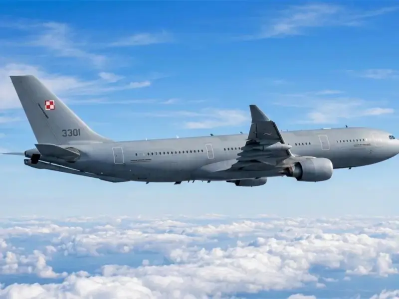 Szary samolot Airbus A330-300 z numerem 3301 i polską szachownicą na ogonie leci nad chmurami.