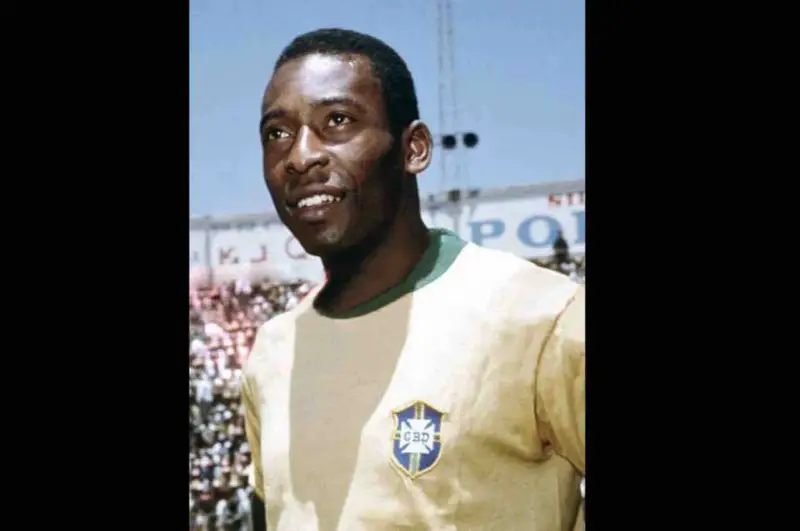 Uśmiechnięty Pelé w żółtej koszulce z herbem Brazylii. Jego niesamowite pelé statystyki mówią same za siebie.