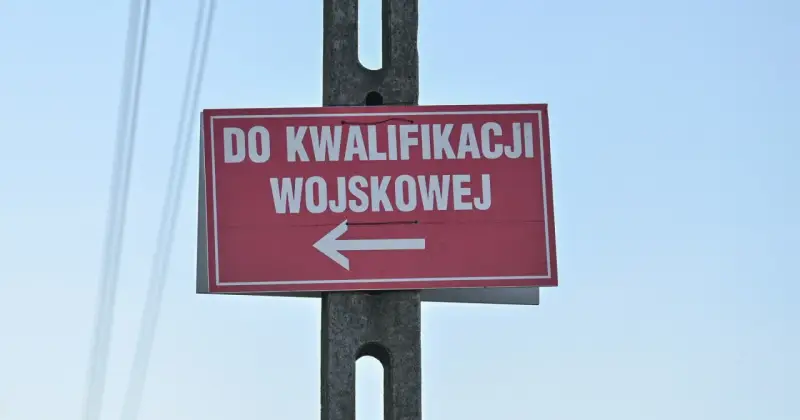 Czerwony znak z białym napisem "DO KWALIFIKACJI WOJSKOWEJ" i strzałką w lewo. Kategoria: d wojsko.