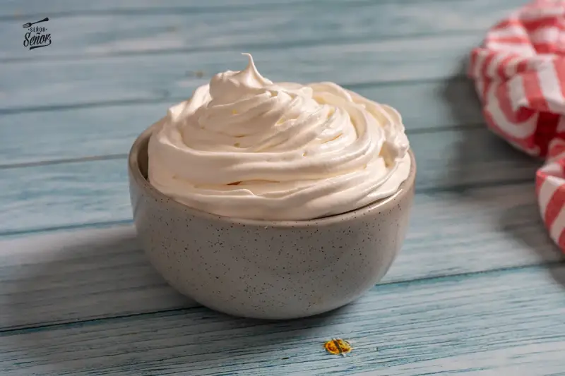 Nata montada perfecta en un cuenco gris, lista para decorar postres.
