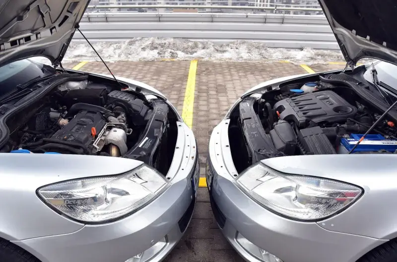 Dwa silniki samochodowe, jeden diesel, drugi benzyna, stoją obok siebie. Różnice w budowie są widoczne, choć oba napędzają auta.