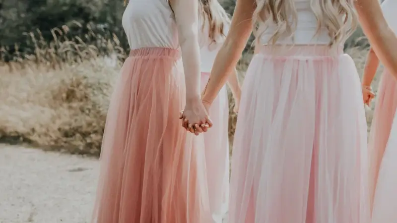 Dziewczyny w tiulowych, pudrowych sukienkach trzymają się za ręce. Ich styl to kwintesencja "soft girl".