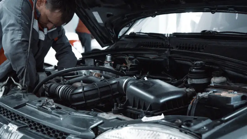 Mechanik pracuje przy silniku, przygotowując się do odpowietrzenia sprzęgła 1.9 TDI.
