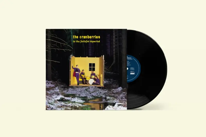 Pochette de l'album "To the Faithful Departed" de The Cranberries, avec un vinyle noir à côté. Le groupe pose dans une structure jaune au milieu d'une forêt enneigée.